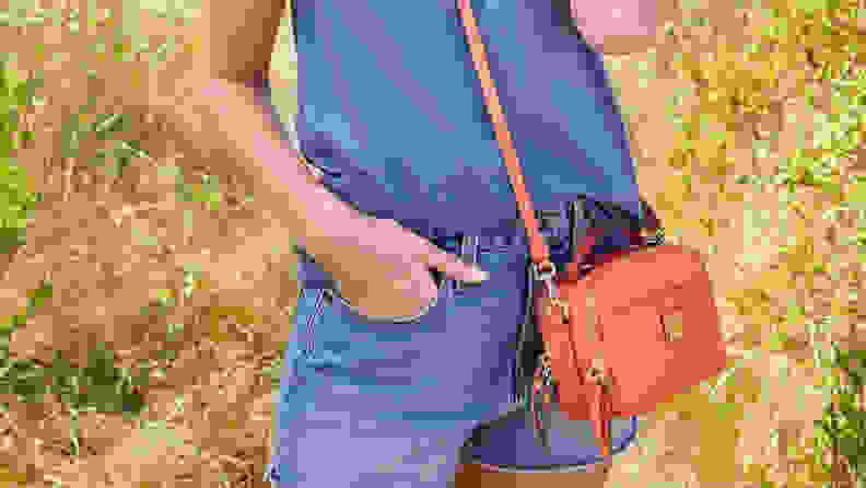 Woman with red Dooney & Bourke crossbody slug across her body.