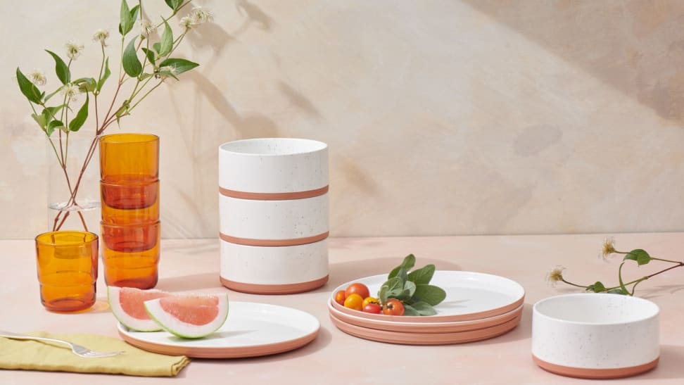 A kitchen counter covered in minimalist plates, bowls, and cups.