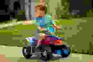 A small child enjoys a ride-on toy from Kid Trax.