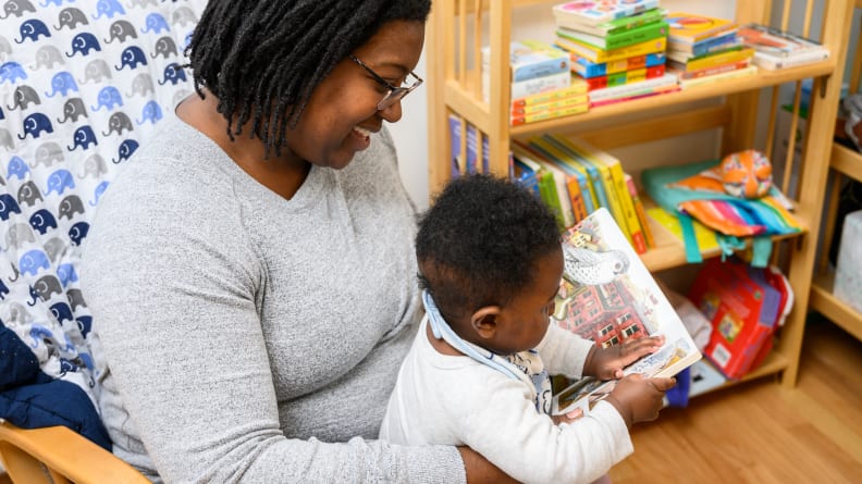 Woman reading book to baby as part of Owlet Dream Lab bedtime routine