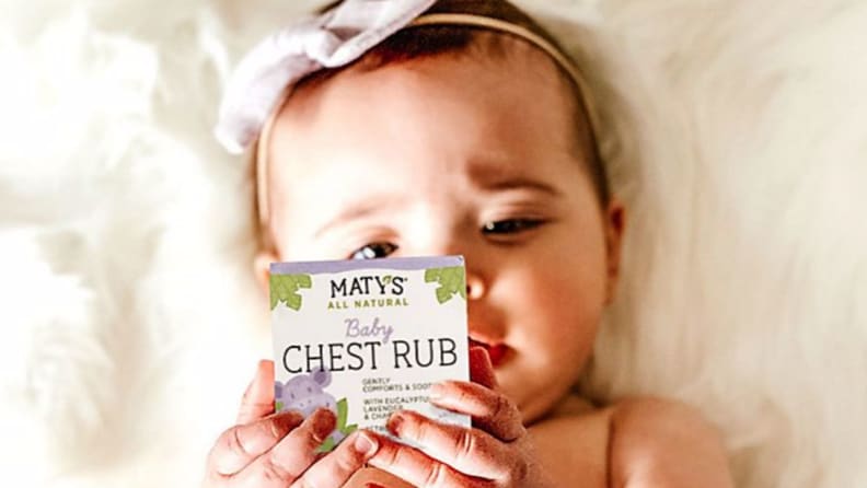 Baby appearing to read box ingredients of Maty's chest rub.
