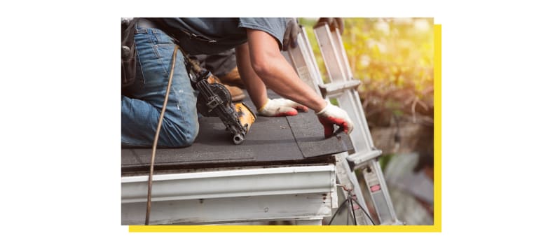 Person installing shingles onto home roof.