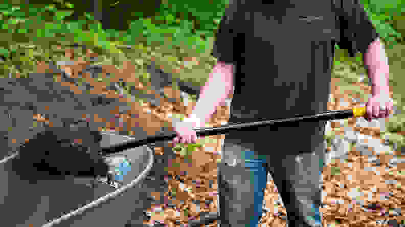 A person scooping dirt with the Fiskars Digging Shovel