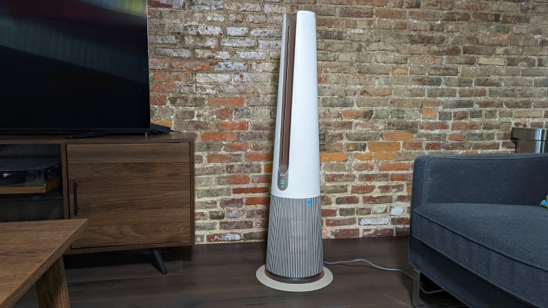 The LG PuriCare AeroTower sitting in a room against a brick wall