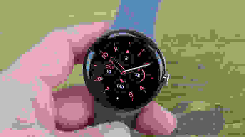 A person's hand holding the Google Pixel smart watch