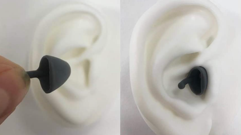 Rubber ear buds being inserted into ears.