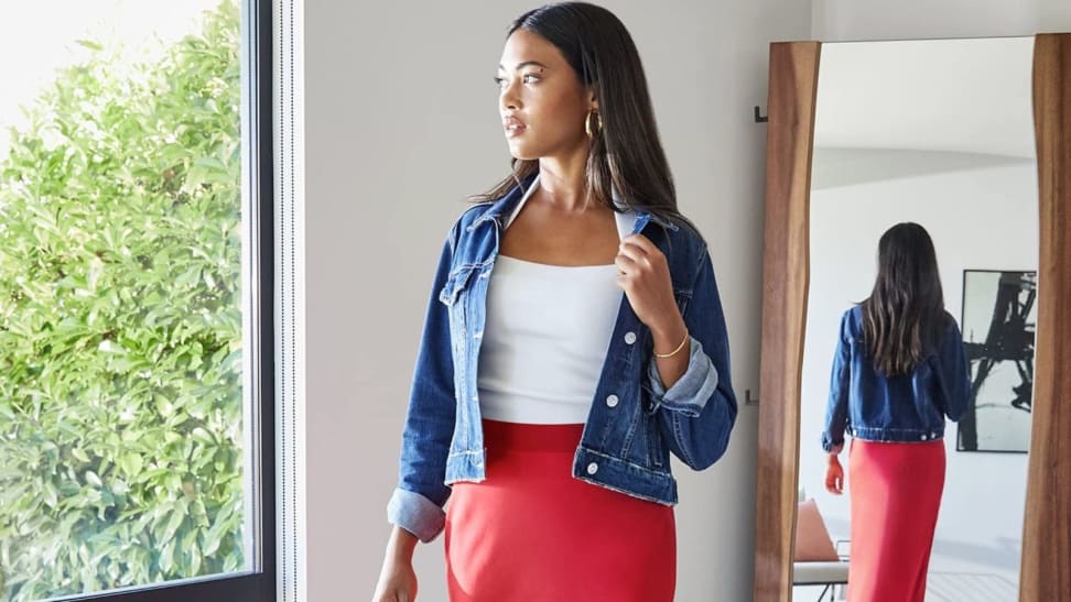 Woman trying on clothes in front of mirror