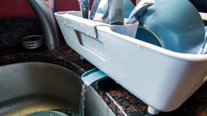 Excess water pours from a dish rack spout.