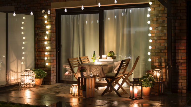 Summer evening terrace with candles, wine and lights.