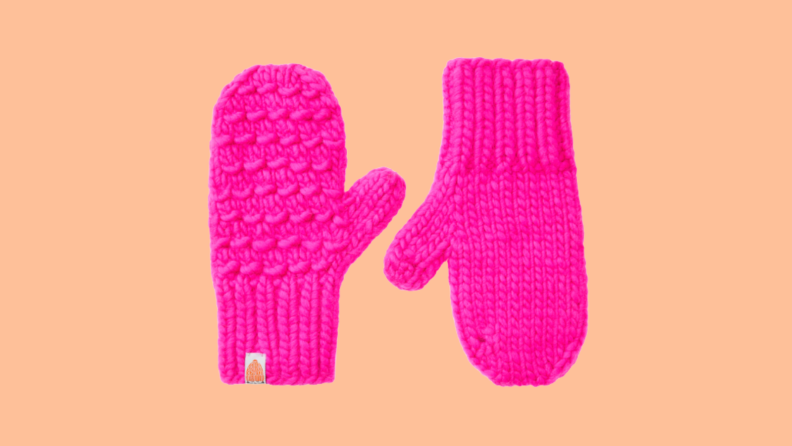 Pink mittens against a peach background
