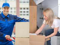 A professional worker with a cardboard box next to a woman working on her closet.