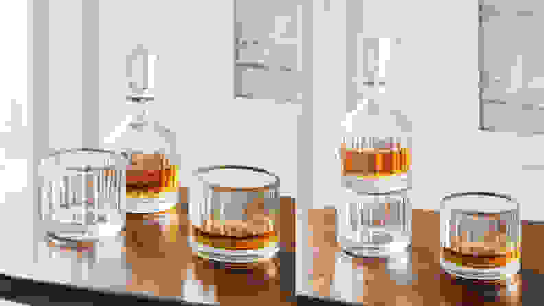 木桌上的醒酒器旁边放着两个威士忌酒杯