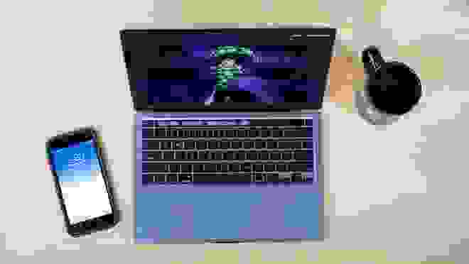 Laptop with phone and mug next to it