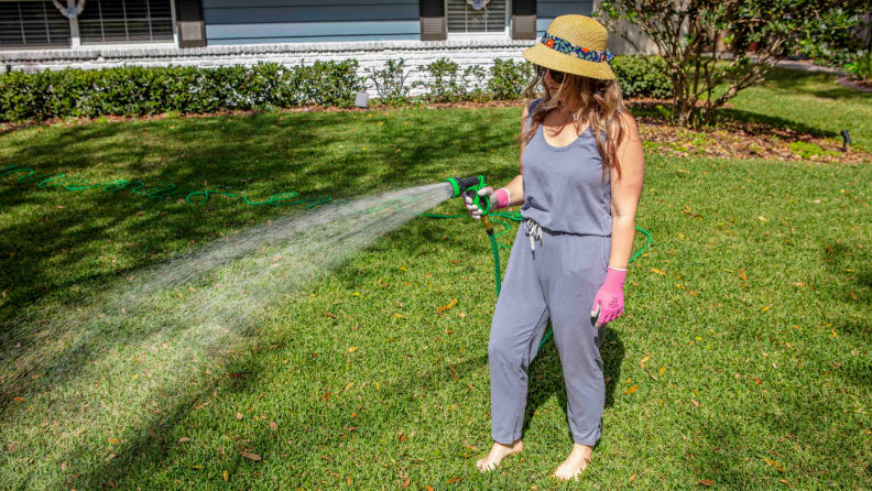 A woman watering the grass