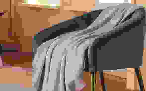 A throw blanket placed on a chair.