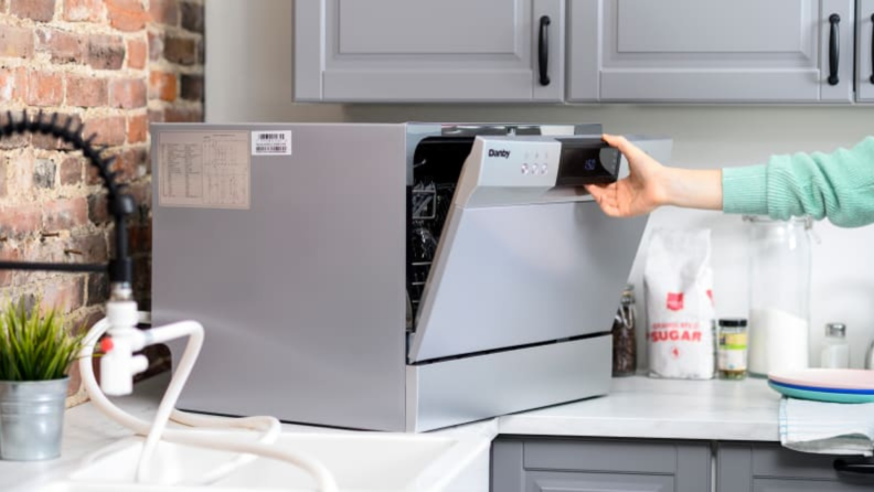 A countertop dishwasher staged on a kitchen counter.