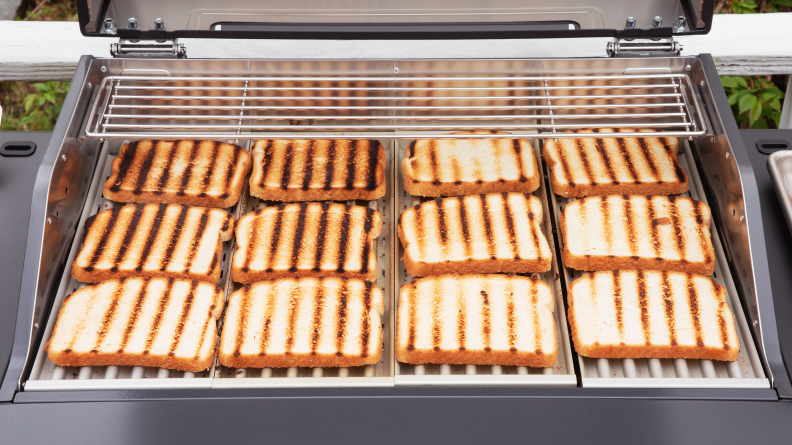 Slices of white bread with even grill makrs spread over the surface of the Current grill.