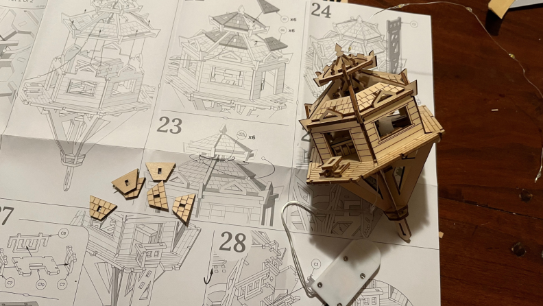Small wooden structure on top of assembly instructions paper.