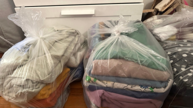 Plastic bags of folded laundry.