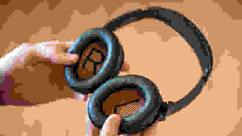 Hands holding a pair of headphones.