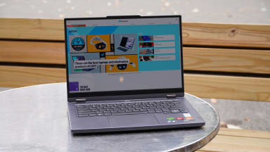 The Lenovo Legion Slim 5 14APH8 open, on a table, with a purple and blue design on the screen.