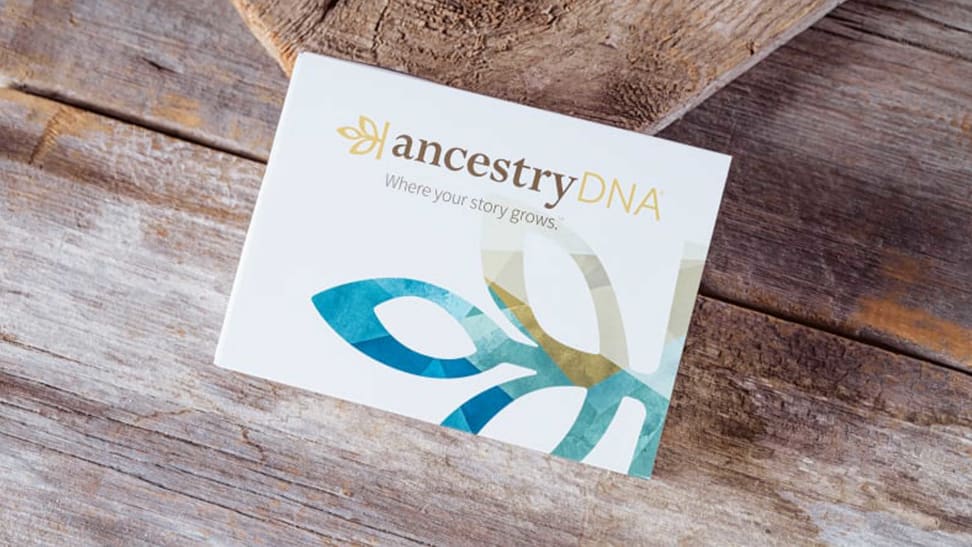An AncestryDNA testing kit on a wooded surface