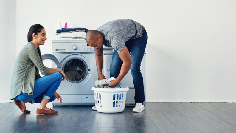 A couple finishes a load of laundry.