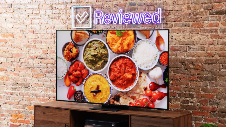 A TCL QM8 LED TV showing a food scene while at an angle.