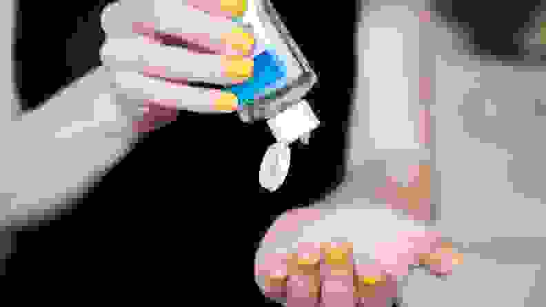 Woman applying hand sanitizer to hands to disinfect them.