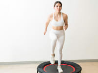 A woman jumping on a rebounder.