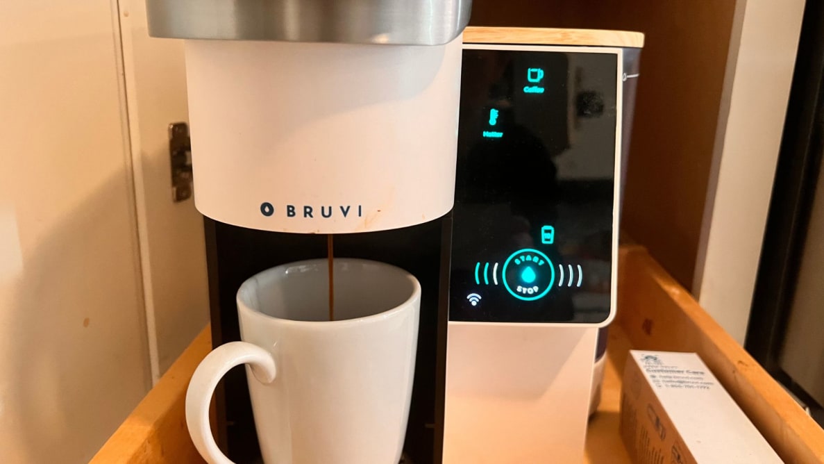 A white Bruvi brewer machine with a coffee mug under the dispenser.