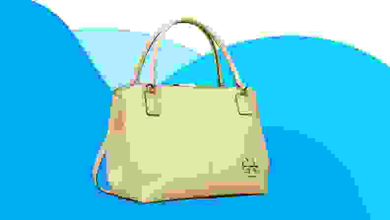 Cream leather handbag in front of blue background.