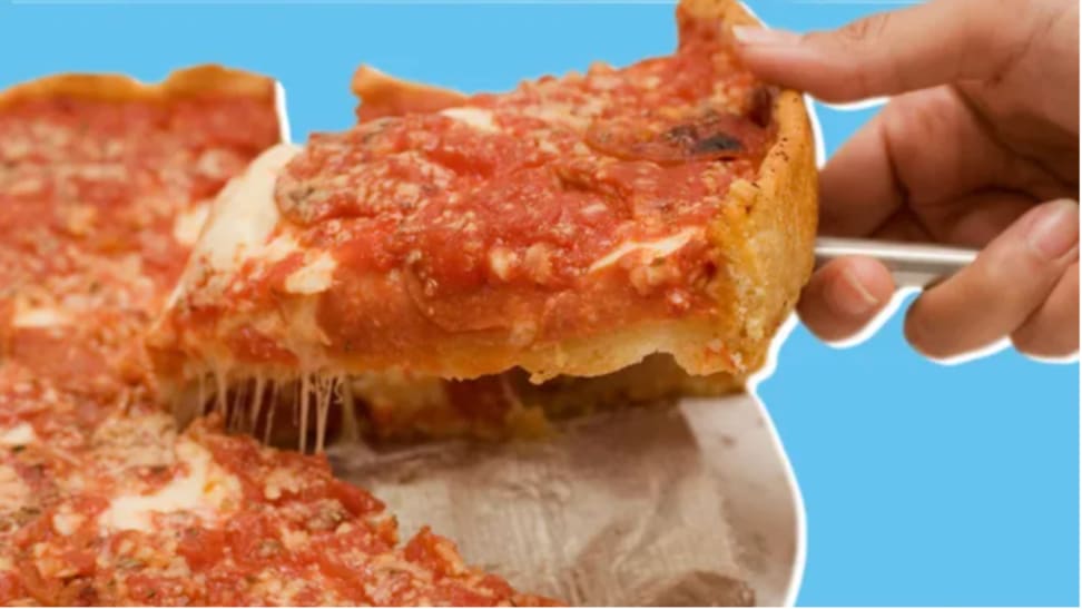 Hand lifting up a slice of pizza against a blue background