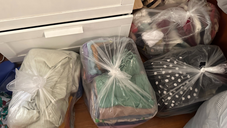 Four plastic bags filled with folded clothes and bedding.