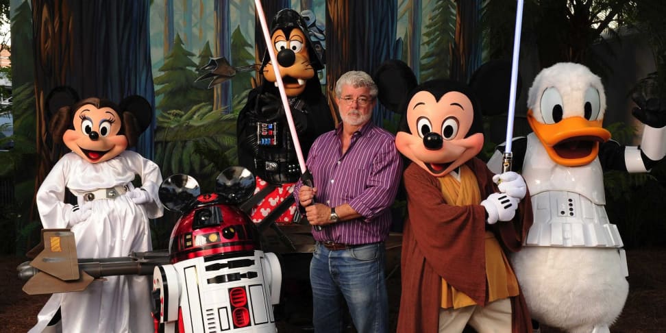 George Lucas posing  with disney characters