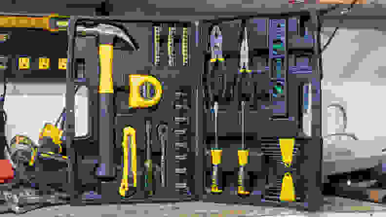The toolkit stands in the corner of a tool-filled work bench. The kit is splayed open, showcasing all the tools inside the case.