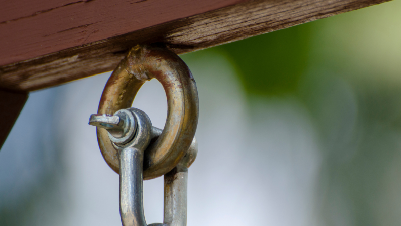 Eye bolt screwed into wooden beam with hook hanging from it