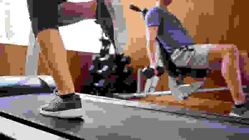 Detail Of Couple In Home Gym Exercising With Weights And Using Running Machine