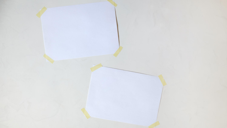 Two blank pieces of paper taped to a wall