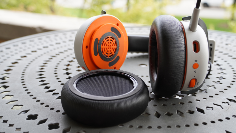 The Beyerdynamic MMX 200 headphones with one of the earpieces off, and exposed the plastic, orange interiors of the headphones.