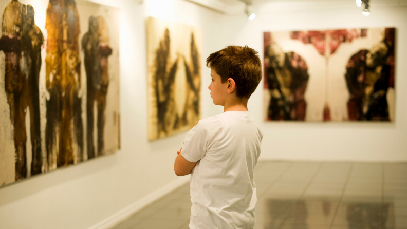 Child looks at paintings in an art museum