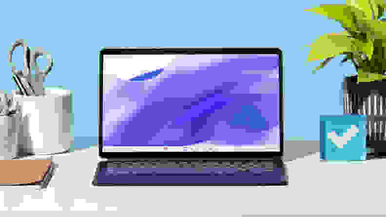 The Lenovo IdeaPad Duet 5 on a white desk, next to office supplies.