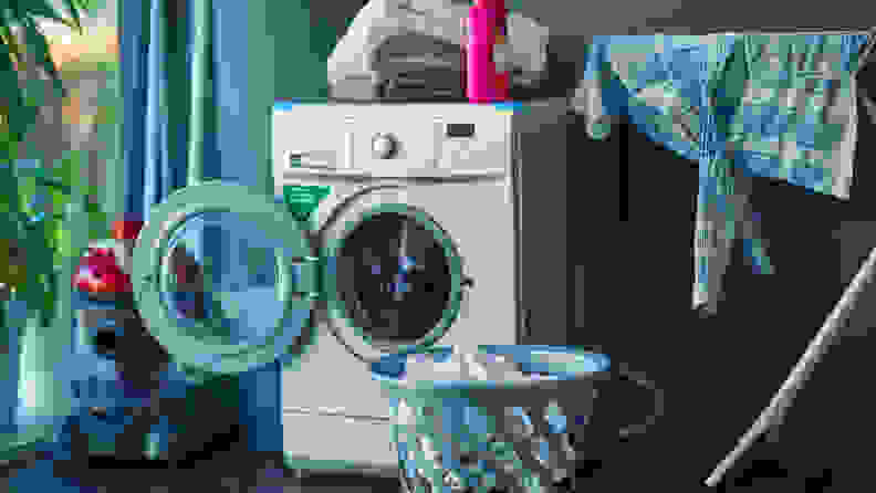 A washer sits in its laundry room, with its door open to dry.