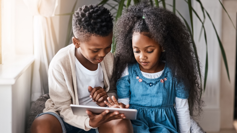 brother and sister using a tablet together