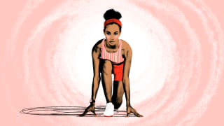 A woman kneeling to start running a race.