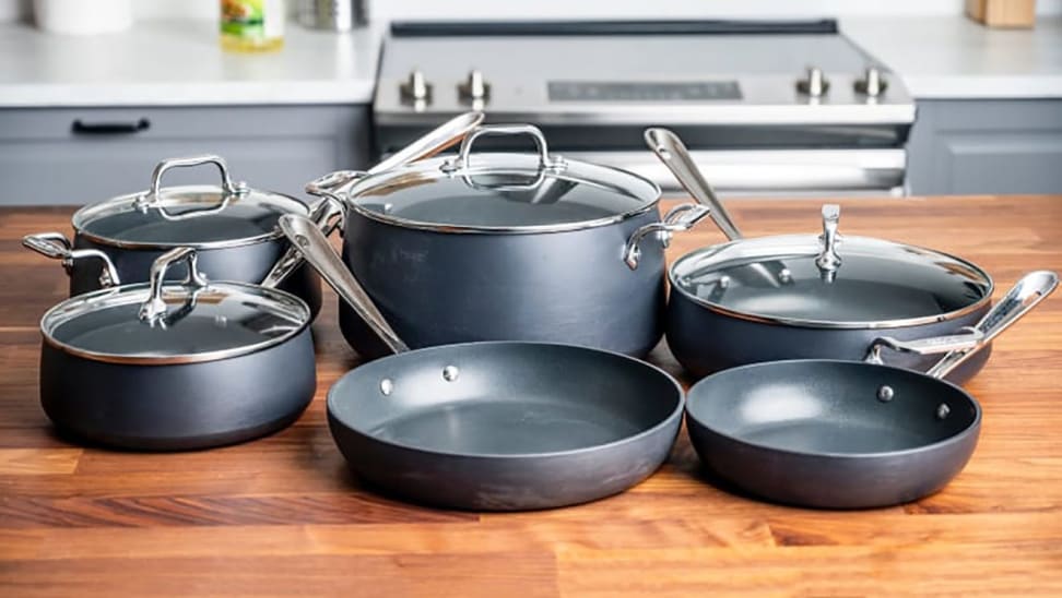 Black and silver cookware set on countertop in kitchen.