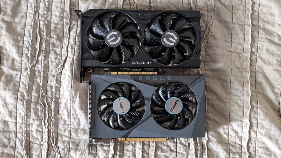 The Nvidia GeForce RTX 3050 and the AMD Radeon RX 6500 XT laying flat on a sheet.