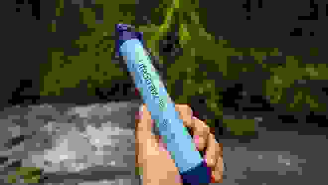 A person holds a LifeStraw water filter