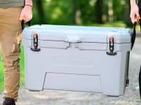A man and a woman carrying an Ozark Trail cooler.