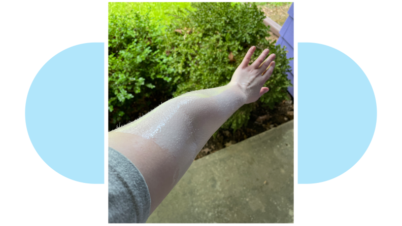 Anna Wenner's arm covered in sunscreen, outside with a blue and white background.